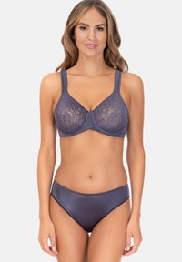 Lila Spitzen-BH mit Bügel und verstellbaren Trägern, kombiniert mit nahtlosen lila Slips. Die Spitze zeigt ein florales Muster für zusätzliche Textur.