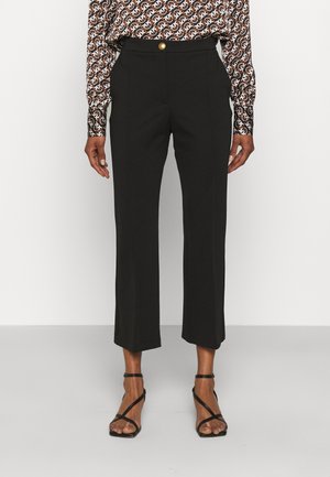 Pantalons noirs ajustés à taille haute, rehaussés d'un bouton doré. Longueur courte et jambes droites. Tissu lisse sans motif visible.