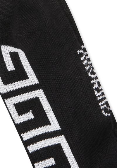 Calzini neri con grande testo bianco sul lato, con una texture a maglia liscia e un design aderente per il comfort.