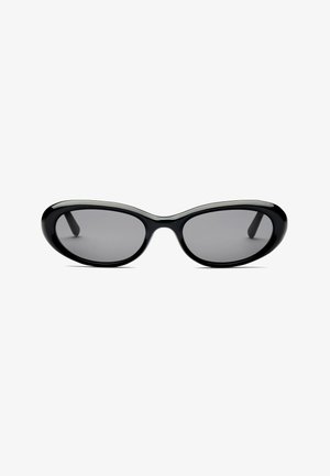 Schwarze ovale Sonnenbrille mit dunkel getönten Gläsern und dicken glänzenden Fassungen, von vorne auf weißem Hintergrund gezeigt.