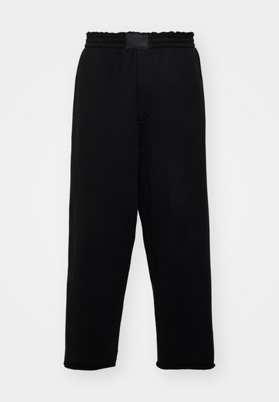 Schwarze Sweatpants mit elastischem Bund, Seitentaschen und lockerer Passform. Hergestellt aus weichem, glattem Stoff mit einheitlicher Textur.