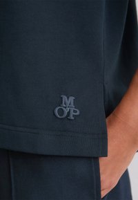 Granatowa koszulka bawełniana o miękkiej fakturze, z haftowanym logo "MOP" w ciemniejszym odcieniu, charakteryzująca się wygodnym, luźnym fasonem.