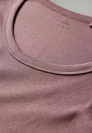 Lila gerippte Baumwollbluse mit runder Ausschnitt und strukturiertem Stoff, die ihre weiche Oberfläche und subtile Schattierung betont.