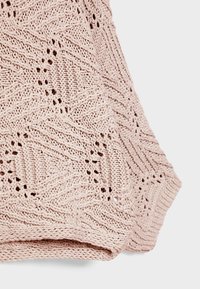Hellrosa gestrickter Stoff mit einem strukturierten Rauten- und Zickzackmuster sowie kleinen Durchbrüchen.