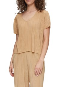 Plissé top in beige met een V-hals, korte mouwen en een ontspannen fit. Heeft verticale plooien en een asymmetrische zoom.