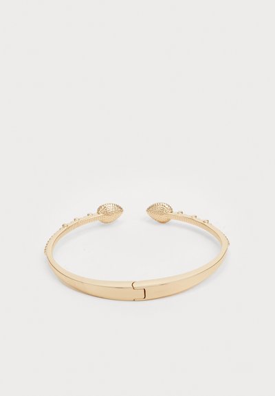Pulsera de oro con extremos texturizados que asemejan conchas marinas, presentando una banda lisa y pequeños adornos en forma de cuentas a lo largo de los lados.