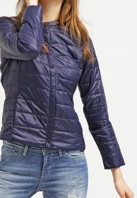 Navy puffer jacket with a quilted design, lightweight material, and long sleeves, featuring a snap button front closure.