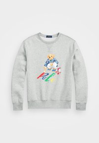 Grå sweatshirt tillverkad av bomull med en färgglad björngrafik, klädd i en blå jacka, med "Polo" i röd, grön och gul under designen.
