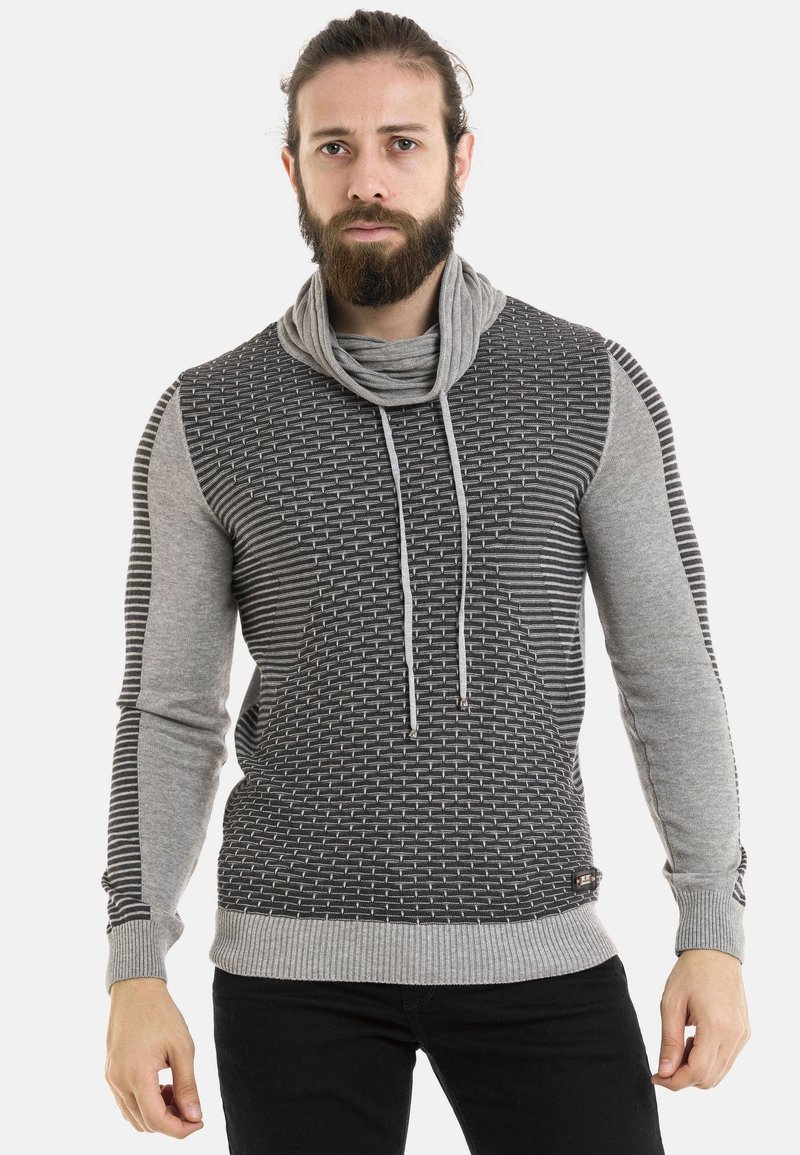 Grau und schwarz gemusterter Pullover mit einem Schalkragen, der eine gewebte Textur und Kordelzüge aufweist, ergänzt durch gerippte Bündchen und Saum.