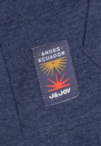 Navyblauw textielpatch met de tekst "ANDES ECUADOR" en "J&JOY" met oranje en gele grafische zonnestralen.