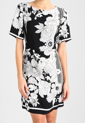 Czarna sukienka z krótkim rękawem, zdobiona białymi kwiatowymi wzorami i paskami. Projekt obejmuje dopasowaną talię i okrągły dekolt.