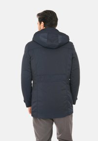 Giacca con cappuccio blu navy caratterizzata da una texture liscia, cuciture visibili e un design posteriore leggermente allungato, adatta per un abbigliamento casual.