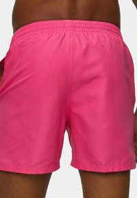 Pantaloni da bagno rosa realizzati in materiale leggero, con vita elastica e una texture liscia, senza motivi visibili o accessori.