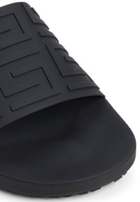 Sandale noire avec une sangle texturée au motif géométrique, en matériau flexible et dotée d'une semelle intérieure rembourrée pour le confort.