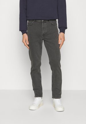 Gray denim jeans with a slim fit, five pockets, belt loops, and contrast stitching. Styled with a navy sweatshirt and white sneakers.