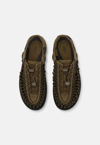 Brune sandaler med et vevd overdel, med snøringdetaljer og en polstret fotseng. Gummisåle for grep. Lett design.
