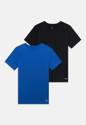 Duas t-shirts de manga curta da Nike, uma preta e uma azul, dispostas em plano com pequenos logótipos brancos da Nike perto da bainha inferior e do decote.