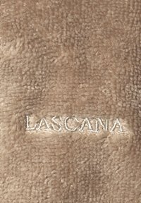 Tan plyschtyg med en mjuk textur, försett med broderad "LASCANA" i ljus tråd längs botten.