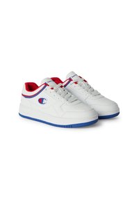 Sneakers bianchi con suole in gomma blu, dettagli rossi e blu, e parte superiore in pelle testurizzata. Presentano un patch logo sul lato.