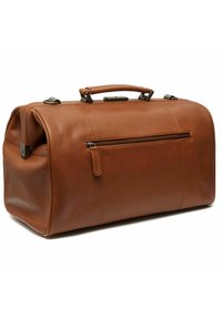 Borsa da viaggio in pelle marrone con una tasca con cerniera, forma strutturata, manico corto e superficie liscia. Presenta dettagli di cucitura.