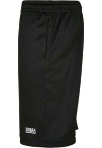 Shorts de sport noirs en tissu en maille respirante ; comprennent une taille élastique et un petit logo sur l'ourlet inférieur.