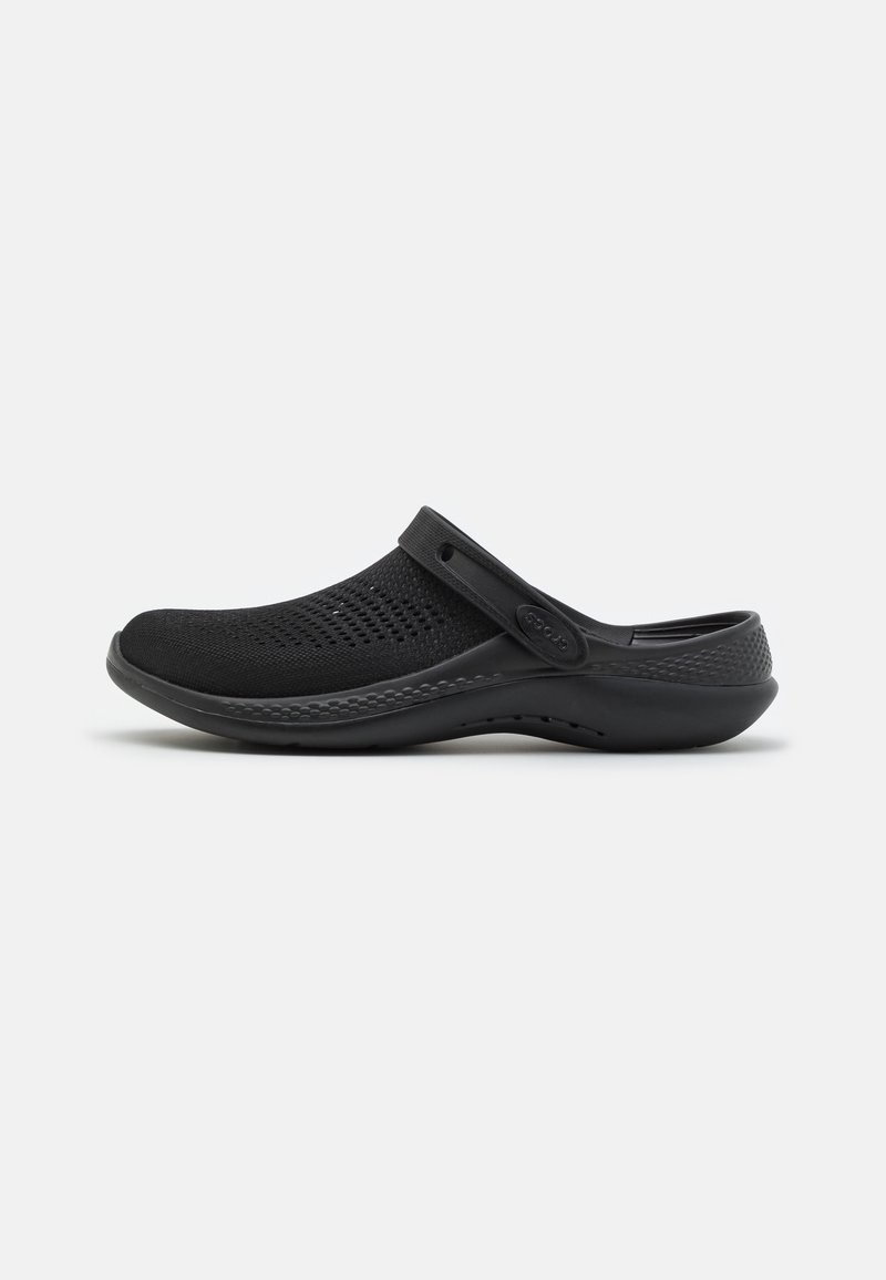 Sabot noir à enfiler avec dessus en mesh respirant, bride de talon réglable, semelle rembourrée et talon texturé pour un usage casual.