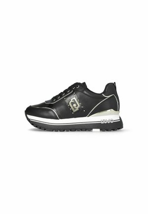 Sneaker in pelle nera con accenti bianchi, borchie metalliche e dettagli con logo. Presenta una suola in gomma robusta e lacci. Design elegante e atletico.