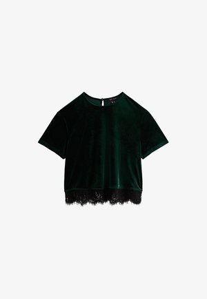Groene fluwelen crop top met korte mouwen, een zwarte kantrand en een klein openingetje met sleutelgat aan de achterkant. Gladde textuur, eenvoudig ontwerp.