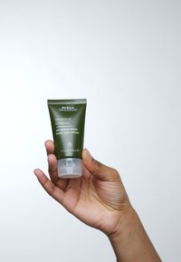 Tube verte de lotion contrôlante à l'huile Aveda Botanical Kinetics. Présente un texte blanc, un bas transparent et un bouchon flip-top. Taille de 50 ml.