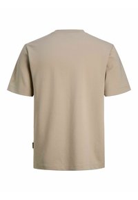 T-shirt en coton beige à manches courtes et col rond. Présente un ourlet droit et une petite étiquette sur le côté. Design simple et uni.