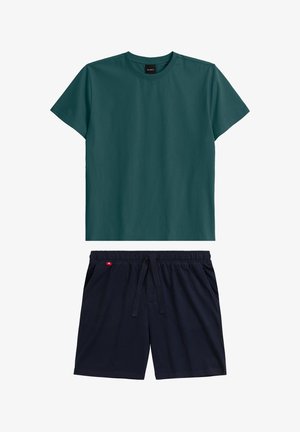 Ciemnoniebieski t-shirt krótki rękaw z okrągłym dekoltem, w zestawieniu z granatowymi szortami na sznurku z dwoma kieszeniami i małą czerwoną metką na pasku.