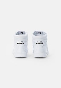 Bílé vysoké tenisky z syntetické kůže. Mají polstrovaný límec, hladký povrch a černé logo na patě. Jednoduchý design.