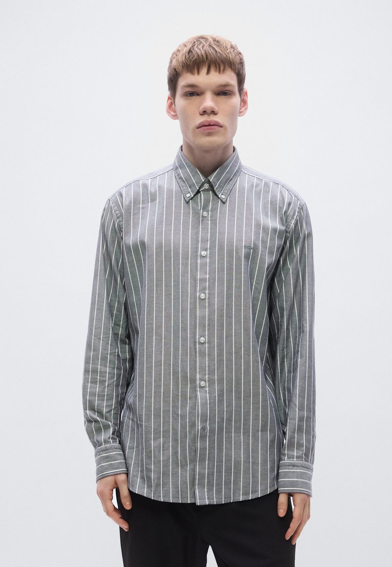 Szürke-fehér csíkos, pamutból készült gombos ing, hegyes gallérral, hosszú ujjakkal és lekerekített szegéllyel. Finom logó részletet tartalmaz.