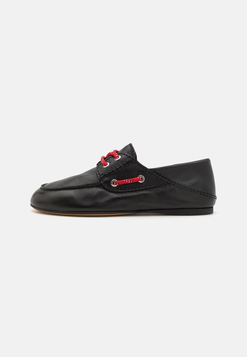 Scarpa in pelle nera con superficie liscia, punta rotonda e lacci rossi attraverso occhielli in metallo. Design minimalista con suola piatta.