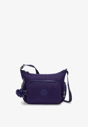 Borsa a tracolla viola con tasca frontale con zip, cintura regolabile e piccolo portachiavi in peluche attaccato al cursore della zip.