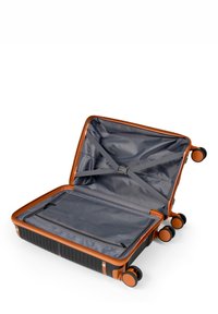 Valigia rigida con accenti arancioni, corpo nero, quattro ruote, chiusura con zip, interno grigio con cinghie e una tasca con zip.