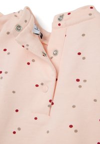 Camisa corta de manga larga color rosa claro con pequeños lunares rojos, marrones y beige. Cuenta con botones a presión en el cuello y una textura de tela suave.
