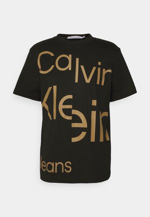 Sort bomulds t-shirt med fed gylden tekst, der viser "Calvin Klein Jeans" i varieret typografi og størrelser, med korte ærmer og rund hals.