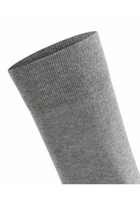 Chaussette en coton gris avec une texture côtelée, comportant un revers au niveau de l'ouverture. La surface est lisse avec une couleur subtile et uniforme.