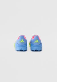 Niebieskie buty sportowe z zielonymi akcentami i różowymi detalami na pięcie, z teksturowaną siateczką i formowaną gumową podeszwą z kolcami dla lepszej trakcji.