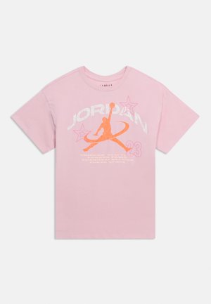 T-shirt rose clair à manches courtes avec logo Jumpman orange, texte blanc « JORDAN », deux contours d'étoiles et numéro « 23 » sur le devant.