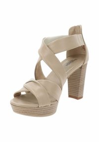 Sandal in beige con tacco alto, dotato di cinturini in pelle incrociati e un tacco spesso e strutturato. Design open-toe con un leggero plateau.