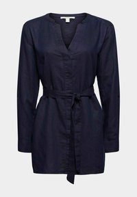 Tunique bleu marine avec un décolleté en V, des manches longues et une ceinture nouée à la taille. Confectionnée en tissu lisse avec un léger éclat.