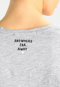 Šedé tričko s kulatým výstřihem a krátkými rukávy, na zadní straně s nápisem "ANYWHERE FAR AWAY" a malým srdíčkem.