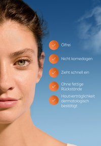 Close-up of a face with light skin tone, showcasing clear skin texture. Text highlights product features in German, on a blue background.