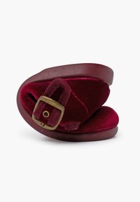 Bordeauxfluwelen instapsandaal met een gebogen houten basis, voorzien van een zijgespdetail en een comfortabele binnenvoering.