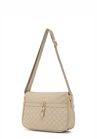 Borsa a tracolla trapuntata color beige con chiusura in metallo dorato, tracolla regolabile e logo in rilievo sul davanti. Texture liscia.
