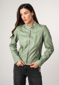 Giacca in pelle verde menta con zip frontale, colletto rialzato e due tasche laterali con zip; presenta dettagli cuciti e un design aderente.
