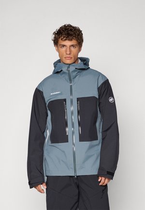 Men's Mammut jacket featuring a blue-gray upper with black sleeves and two zippered chest pockets; made from durable, weather-resistant material.