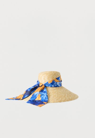 Chapeau de paille à large bord avec un foulard floral bleu et orange noué autour de la calotte sur fond blanc.